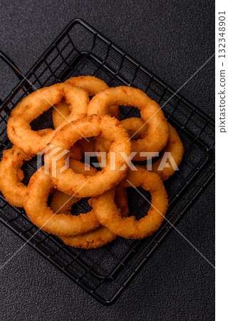 Onion rings or fried squid in breadcrumbs with sauce, takeaway food. Onion rings fried 132348901