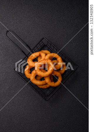 Onion rings or fried squid in breadcrumbs with sauce, takeaway food. Onion rings fried 132348905