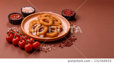 Onion rings or fried squid in breadcrumbs with sauce, takeaway food. Onion rings fried 132348919