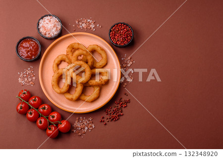 Onion rings or fried squid in breadcrumbs with sauce, takeaway food. Onion rings fried 132348920
