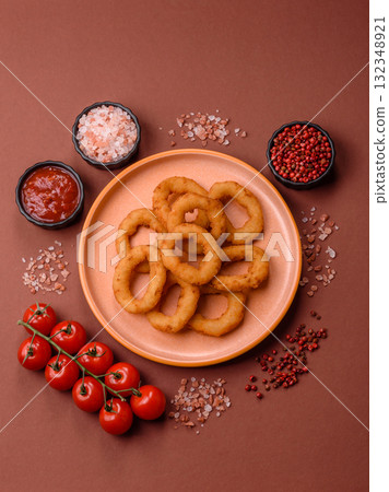 Onion rings or fried squid in breadcrumbs with sauce, takeaway food. Onion rings fried 132348921