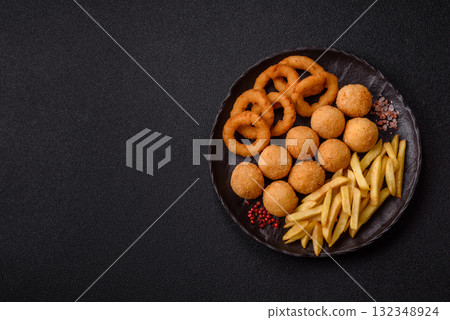Fast food, cheese balls, onion or squid rings and French fries. Junk food as a background Fast food, cheese balls, onion or squid rings and French fries. Junk food as a background 132348924