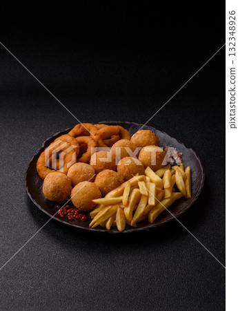 Fast food, cheese balls, onion or squid rings and French fries. Junk food as a background 132348926