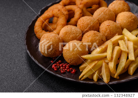 Fast food, cheese balls, onion or squid rings and French fries. Junk food as a background Fast food, cheese balls, onion or squid rings and French fries. Junk food as a background 132348927