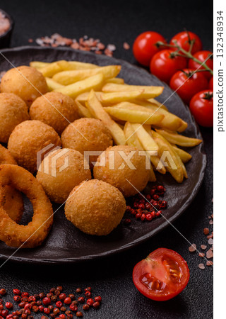 Fast food, cheese balls, onion or squid rings and French fries. Junk food as a background Fast food, cheese balls, onion or squid rings and French fries. Junk food as a background 132348934