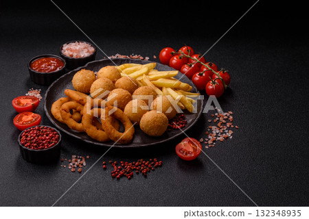Fast food, cheese balls, onion or squid rings and French fries. Junk food as a background Fast food, cheese balls, onion or squid rings and French fries. Junk food as a background 132348935