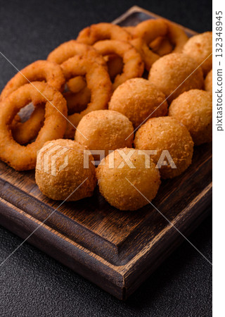 Fast food, cheese balls, onion or squid rings and French fries. Junk food as a background Fast food, cheese balls, onion or squid rings and French fries. Junk food as a background 132348945