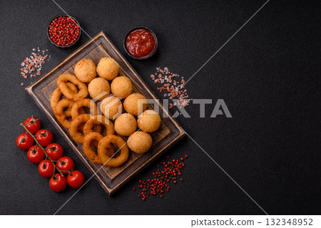Fast food, cheese balls, onion or squid rings and French fries. Junk food as a background 132348952