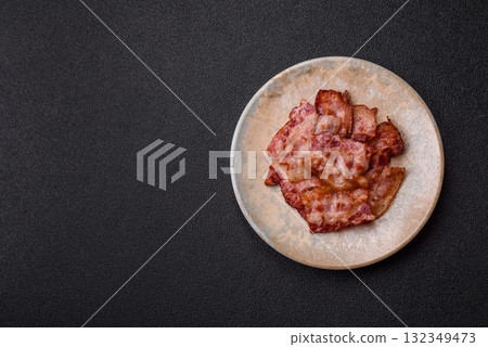 Cooked crispy fried pork bacon strips for a hearty breakfast. Fried bacon strips 132349473