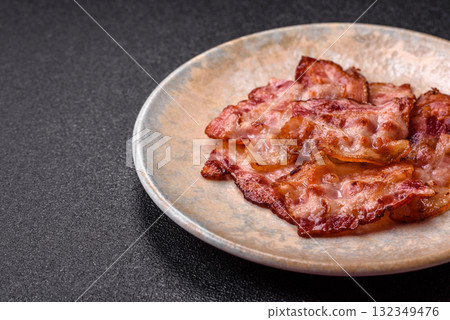 Cooked crispy fried pork bacon strips for a hearty breakfast. Fried bacon strips Cooked crispy fried pork bacon strips for a hearty breakfast. Fried bacon strips 132349476