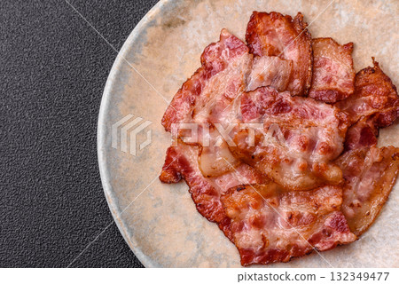 Cooked crispy fried pork bacon strips for a hearty breakfast. Fried bacon strips Cooked crispy fried pork bacon strips for a hearty breakfast. Fried bacon strips 132349477
