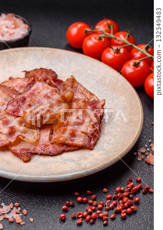 Cooked crispy fried pork bacon strips for a hearty breakfast. Fried bacon strips Cooked crispy fried pork bacon strips for a hearty breakfast. Fried bacon strips 132349483