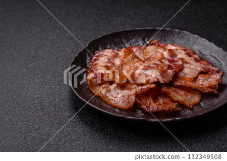 Cooked crispy fried pork bacon strips for a hearty breakfast. Fried bacon strips Cooked crispy fried pork bacon strips for a hearty breakfast. Fried bacon strips 132349508