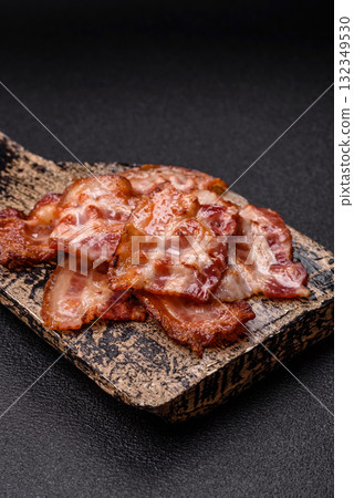 Cooked crispy fried pork bacon strips for a hearty breakfast. Fried bacon strips 132349530