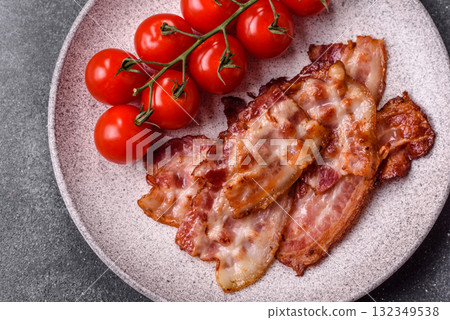 Cooked crispy fried pork bacon strips for a hearty breakfast. Fried bacon strips Cooked crispy fried pork bacon strips for a hearty breakfast. Fried bacon strips 132349538