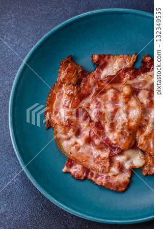 Cooked crispy fried pork bacon strips for a hearty breakfast. Fried bacon strips Cooked crispy fried pork bacon strips for a hearty breakfast. Fried bacon strips 132349555