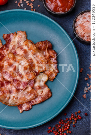 Cooked crispy fried pork bacon strips for a hearty breakfast. Fried bacon strips Cooked crispy fried pork bacon strips for a hearty breakfast. Fried bacon strips 132349559