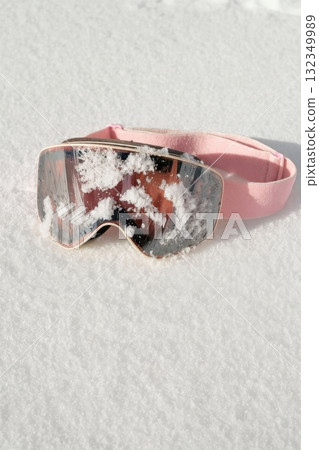 Pink ski goggles covered with snow on white background Pink ski goggles covered with snow on white background 132349989