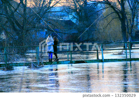 Young girls are photographed on background of flooding in spring. Natural disaster 132350029