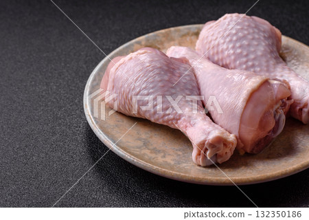 Raw chicken or turkey legs as a food background for cooking on a barbecue or grill. Chicken raw legs Raw chicken or turkey legs as a food background for cooking on a barbecue or grill. Chicken raw legs 132350186