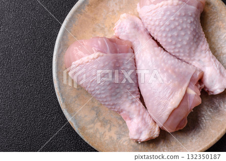 Raw chicken or turkey legs as a food background for cooking on a barbecue or grill. Chicken raw legs Raw chicken or turkey legs as a food background for cooking on a barbecue or grill. Chicken raw legs 132350187