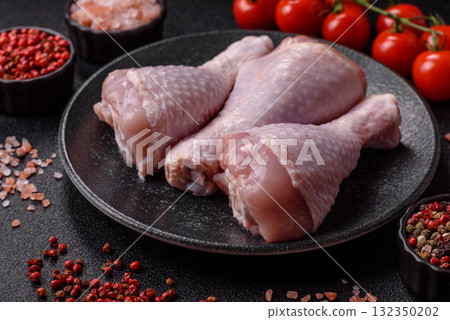 Raw chicken or turkey legs as a food background for cooking on a barbecue or grill. Chicken raw legs Raw chicken or turkey legs as a food background for cooking on a barbecue or grill. Chicken raw legs 132350202