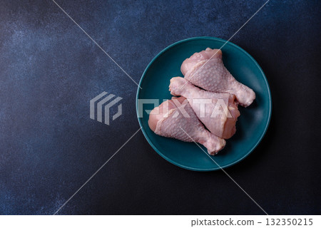 Raw chicken or turkey legs as a food background for cooking on a barbecue or grill. Chicken raw legs Raw chicken or turkey legs as a food background for cooking on a barbecue or grill. Chicken raw legs 132350215