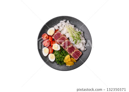 Seafood bowl, tuna tataki fillet slices with rice, oranges, tomatoes and sauce. Tuna bowl 132350371
