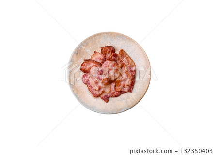 Cooked crispy fried pork bacon strips for a hearty breakfast. Fried bacon strips Cooked crispy fried pork bacon strips for a hearty breakfast. Fried bacon strips 132350403