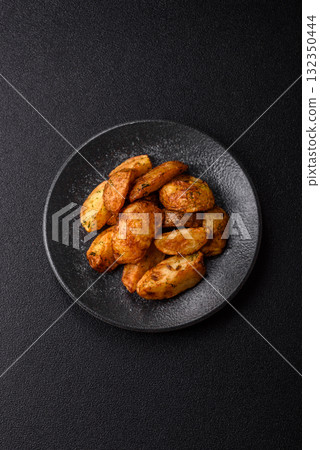 Potato wedges baked with spices, garlic and rosemary. Potato wedges 132350444