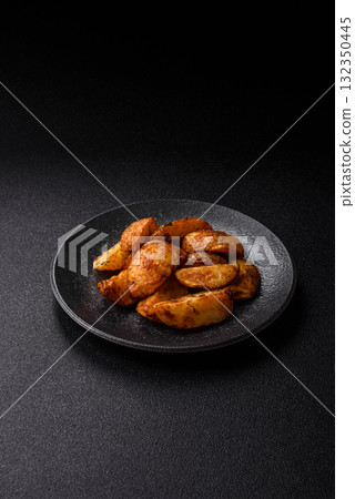 Potato wedges baked with spices, garlic and rosemary. Potato wedges 132350445