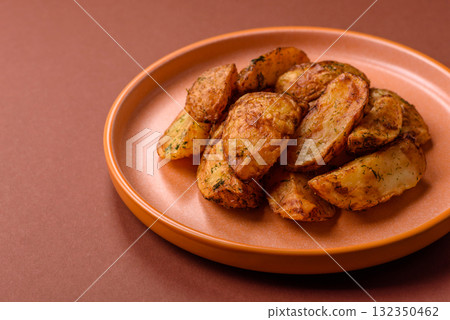 Potato wedges baked with spices, garlic and rosemary. Potato wedges Potato wedges baked with spices, garlic and rosemary. Potato wedges 132350462