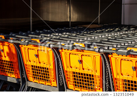 There are stacked shopping carts organized efficiently in the store There are stacked shopping carts organized efficiently in the store 132351049