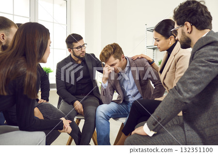 View of the group of young businessmen comforting their frustrated colleague. View of the group of young businessmen comforting their frustrated colleague. 132351100