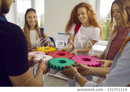 Group of people connect single colored cogwheels to make a gear. Group of people connect single colored cogwheels to make a gear. 132351114