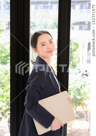 辦公室裡拿著筆記型電腦的日本女人 辦公室裡拿著筆記型電腦的日本女人 132351475