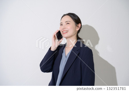 一位女士在白色背景上用智慧型手機說話 132351781