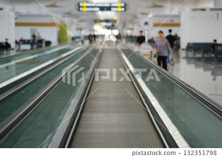 A travelator in the busy airport terminal, where travelers head to their boarding gates during the day. A travelator in the busy airport terminal, where travelers head to their boarding gates during the day. 132351798