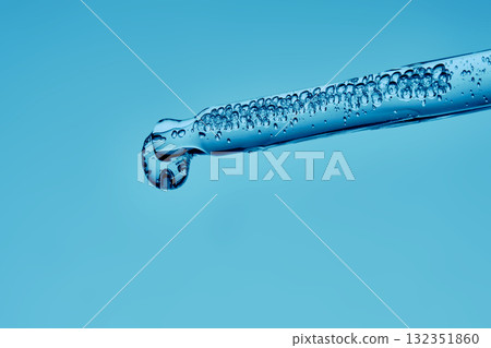 Gel hyaluronic serum in a pipette on a blue background. Gel hyaluronic serum in a pipette on a blue background. 132351860