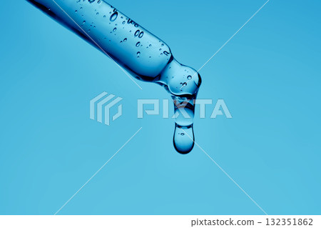 A serum pipette with lots of bubbles on a blue background. 132351862