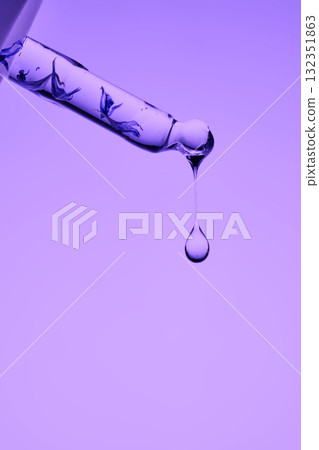 The texture of a cosmetic product with peptides in a pipette on a purple background. The texture of a cosmetic product with peptides in a pipette on a purple background. 132351863