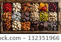 Top view of assorted dried fruits, nuts, and dark chocolate on a wooden tray. Sweet snack, healthy food concept 132351966
