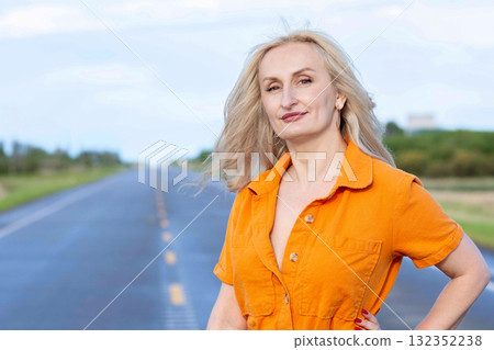 Blonde free woman is on the empty rural road in summer. Blonde free woman is on the empty rural road in summer. 132352238