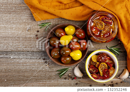 Flatlay of dried cherry tomatoes in a jar and plate with ingredients. Flatlay of dried cherry tomatoes in a jar and plate with ingredients. 132352246
