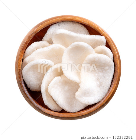 Prawn crackers, shrimp chips in a wooden bowl. Deep-fried crackers made from a dough of tapioka, ground prawns, and seasonings. Popular snack and side dish in Southeast Asian cuisine. Close-up. Photo 132352291