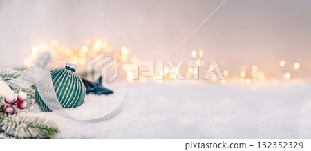 Green Christmas Ornament with Silver Ribbon on Snowy Surface Green Christmas Ornament with Silver Ribbon on Snowy Surface 132352329