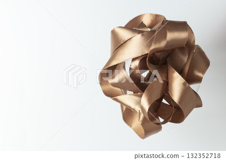 Mocha mousse colored ribbon elegantly placed inside a martini glass on a soft neutral background. 132352718