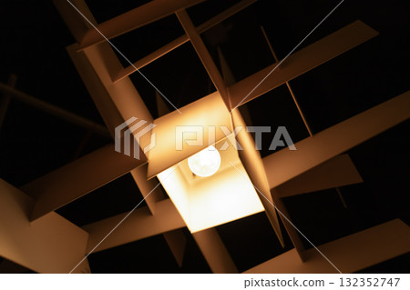 Modern geometric pendant lamp hanging from the ceiling in stylish interior 132352747