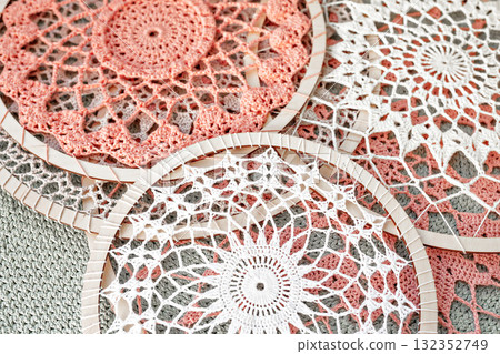 Pink, white and gray cotton crochets dream catcher are lying on the table 132352749