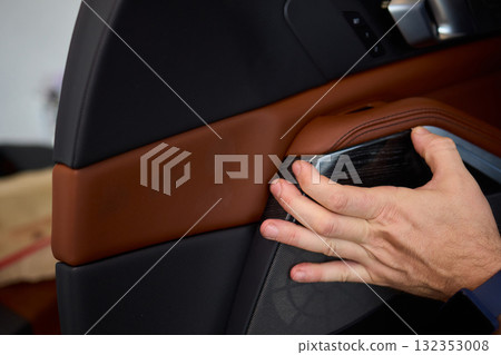 Skilled hands install a car door handle trim, highlighting craftsmanship and precision in design 132353008